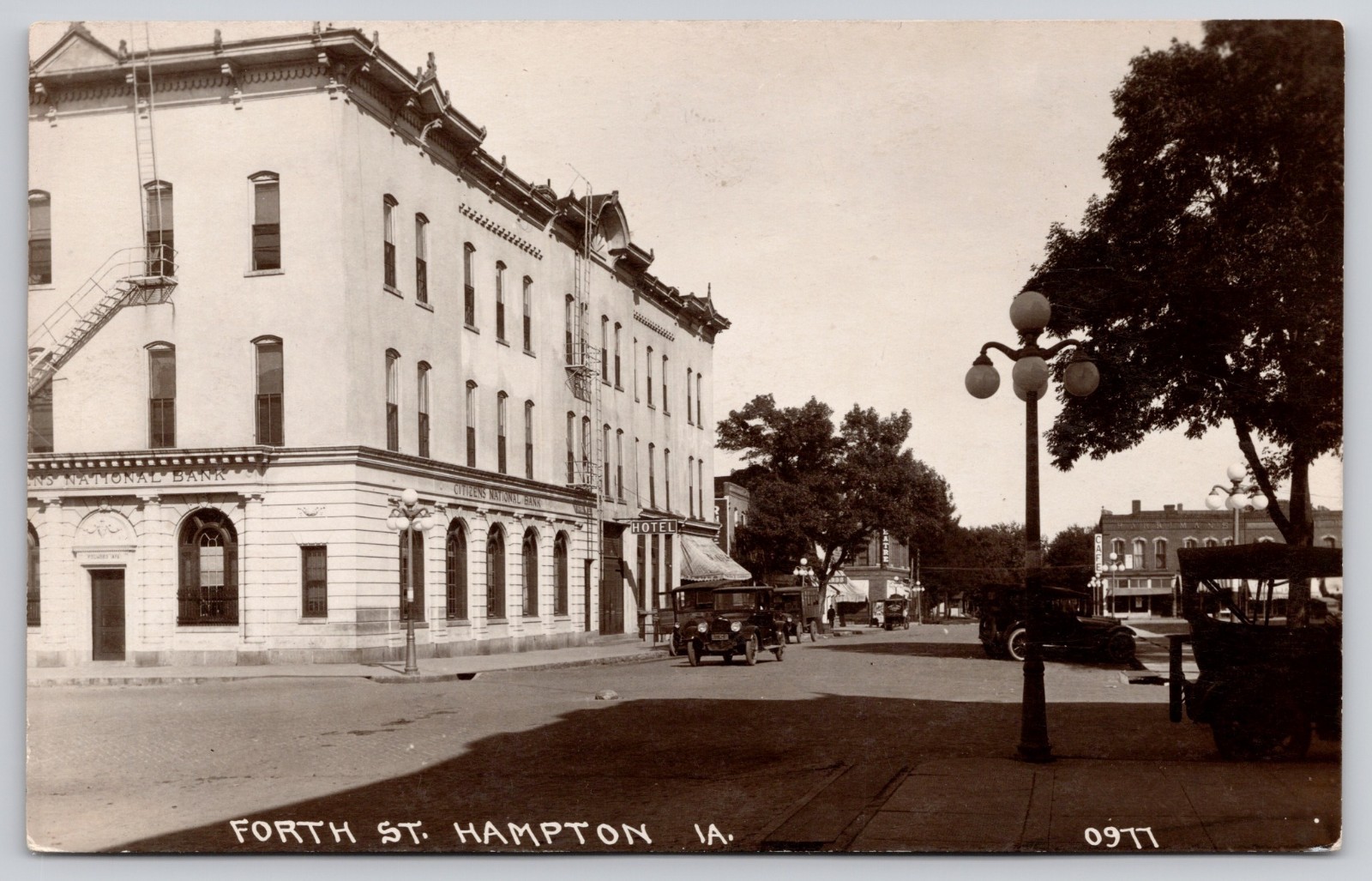 Fourth Street Hampton Iowa IA Bank Hotel Cars RPPC Postcard c1920s