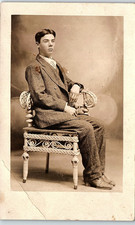 Vintage Postcard Young Man Studio Portrait Wicker Chair Cabinet Photo picture